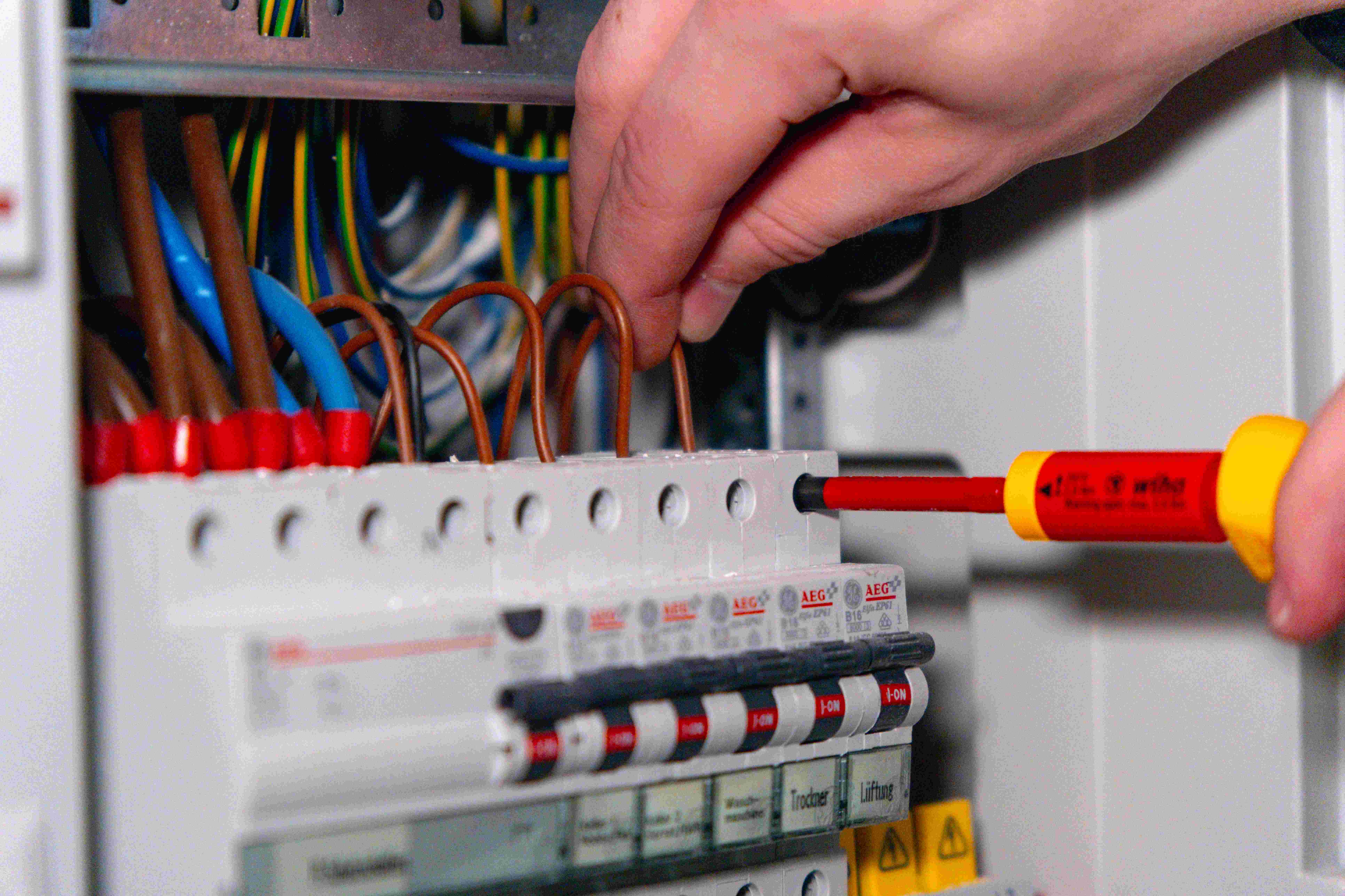 Handwerker, der an einem Stromkasten arbeitet