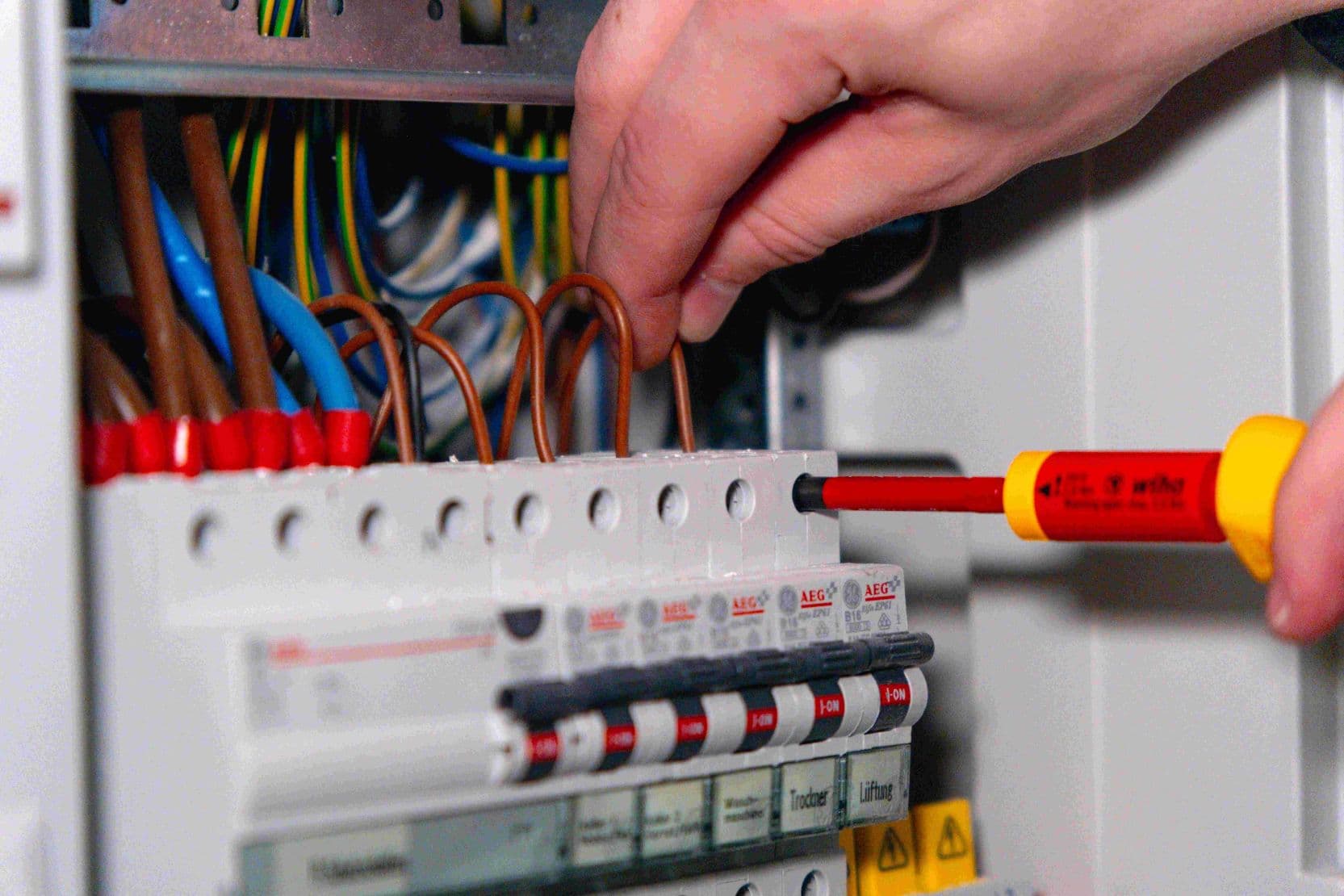 Handwerker, der an einem Stromkasten arbeitet